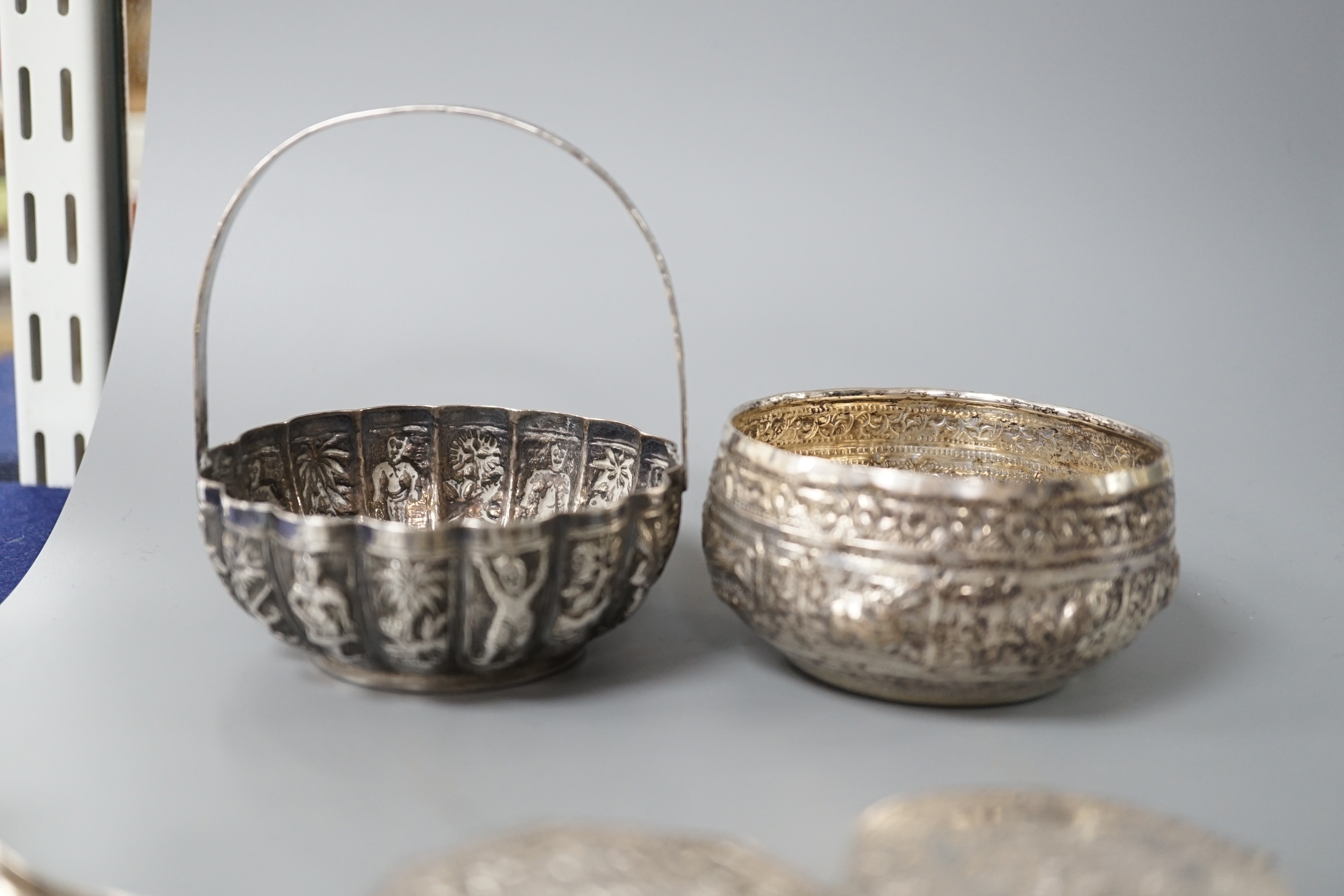 A Burmese? white metal bonbon basket, height 10.1cm and a similar bowl, two Persian white metal boxes and a spoon.